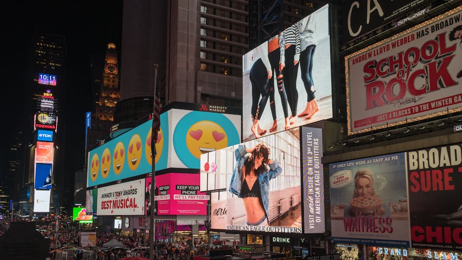 Colorful billboards light up New York City's iconic Times Square at night, with vibrant ads and bustling crowds.