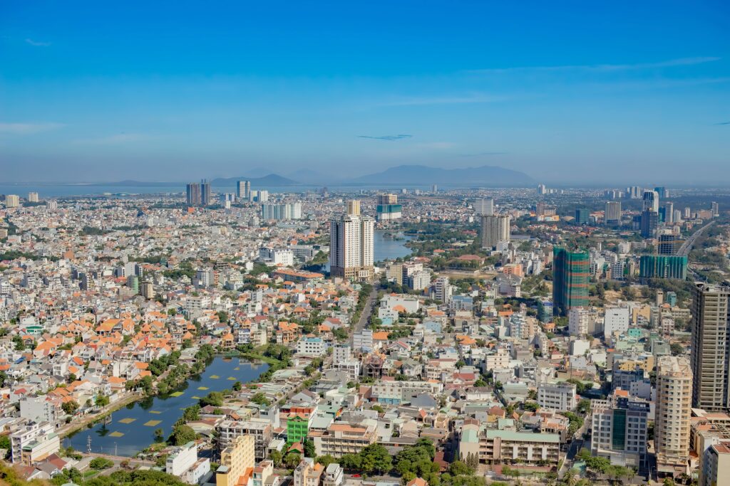 High-angle view of a sprawling cityscape with skyscrapers under a clear blue sky.