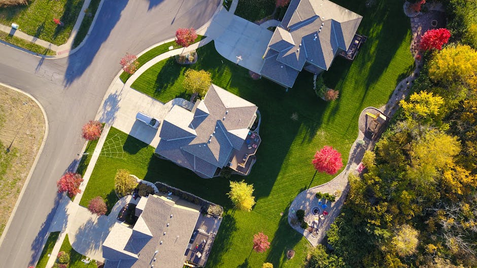 A picturesque aerial view showcasing suburban homes with vibrant gardens and tree-lined streets.