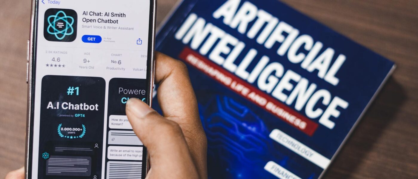 Smartphone displaying AI app with book on AI technology in background.