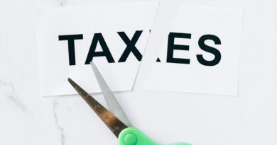 Close-up of scissors cutting the word taxes on a marble background, symbolizing tax reduction.