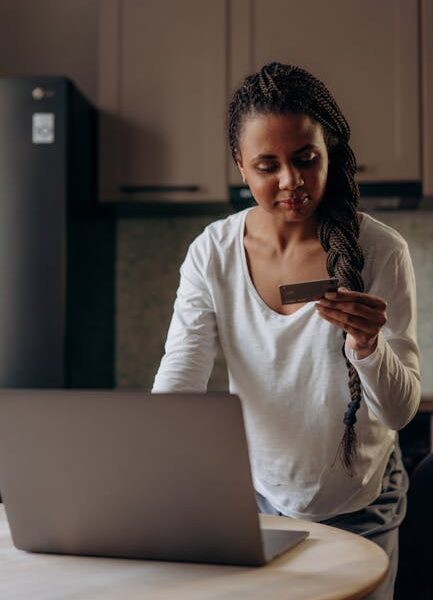 Young woman using laptop and credit card for online shopping at home.