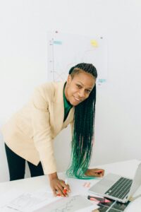 Professional woman analyzing financial charts at a desk with a laptop.