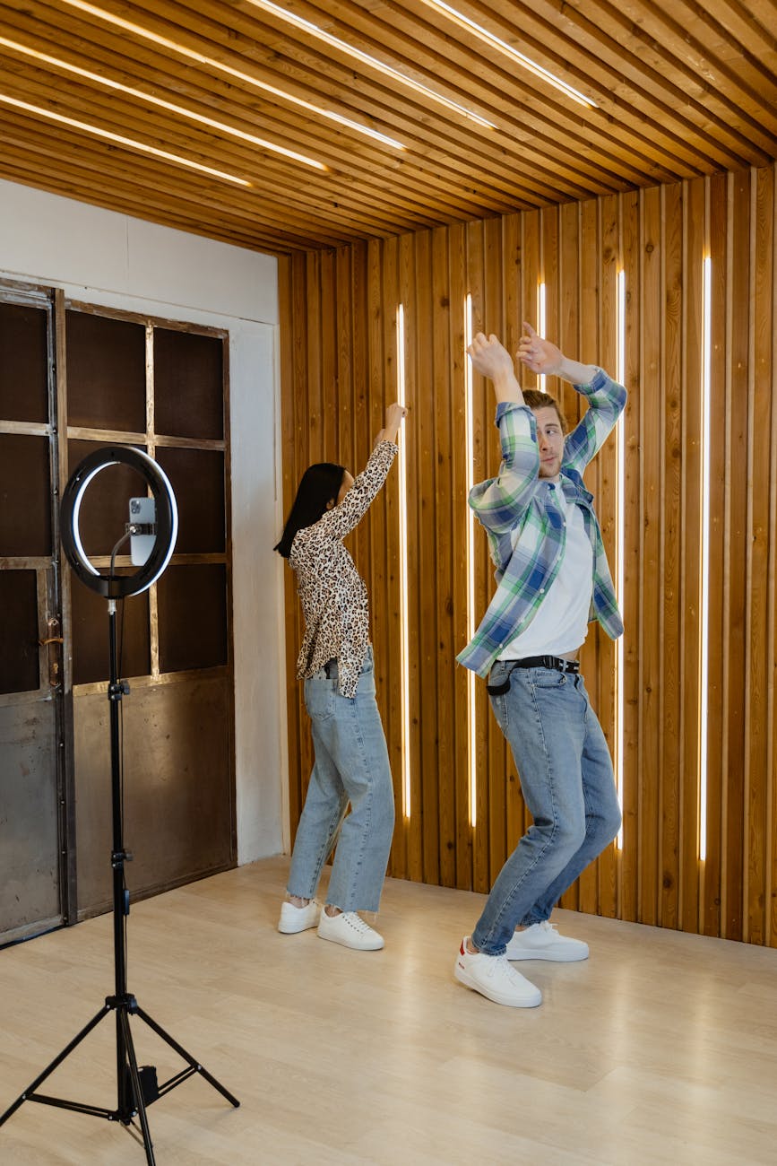 Energetic couple dances in modern living room, creating content for social media.