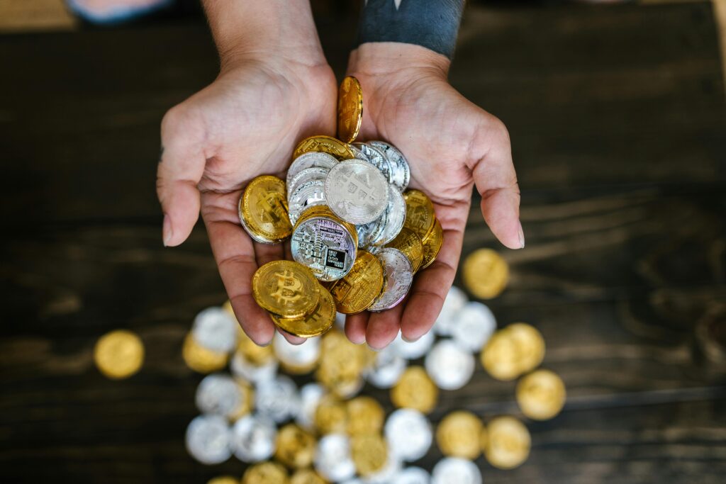 Close-up of hands holding gold and silver cryptocurrency coins symbolizing wealth and finance.