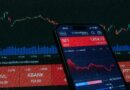 Mobile app showing stock market data with charts on screen.
