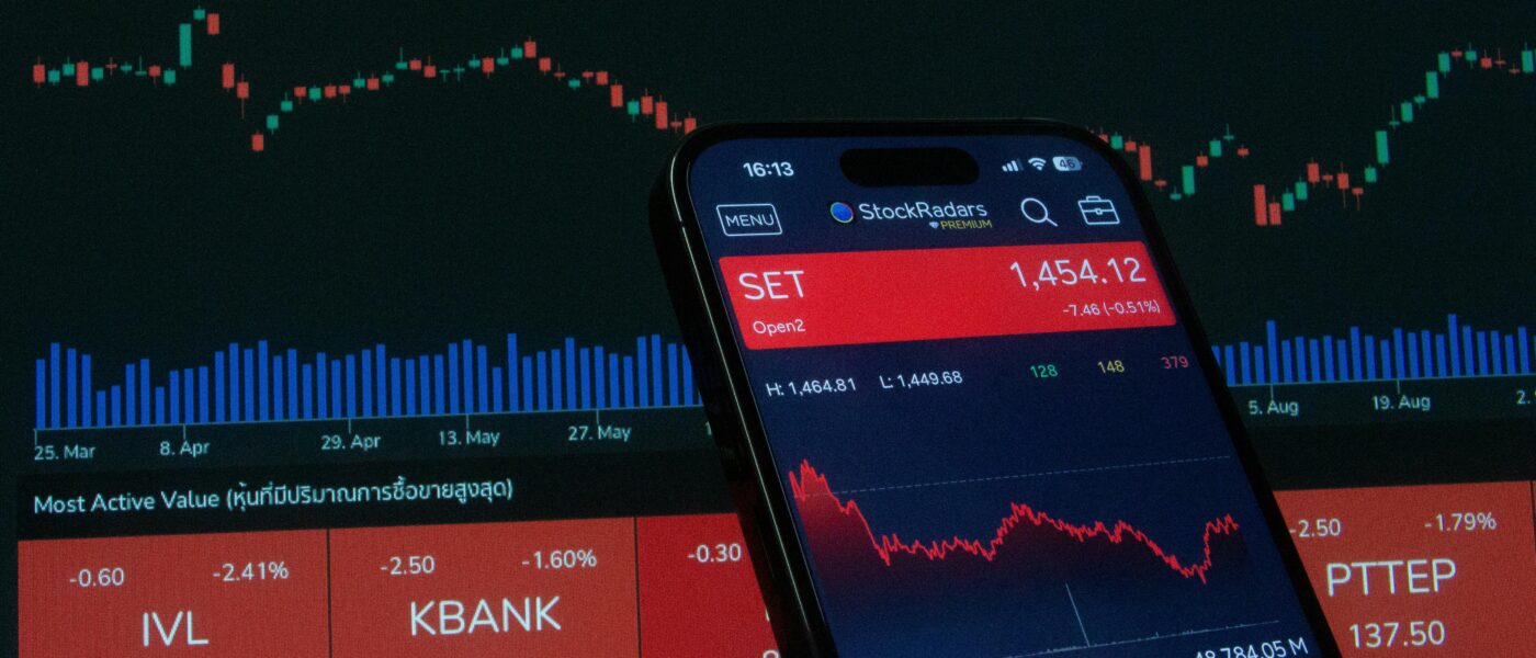 Mobile app showing stock market data with charts on screen.