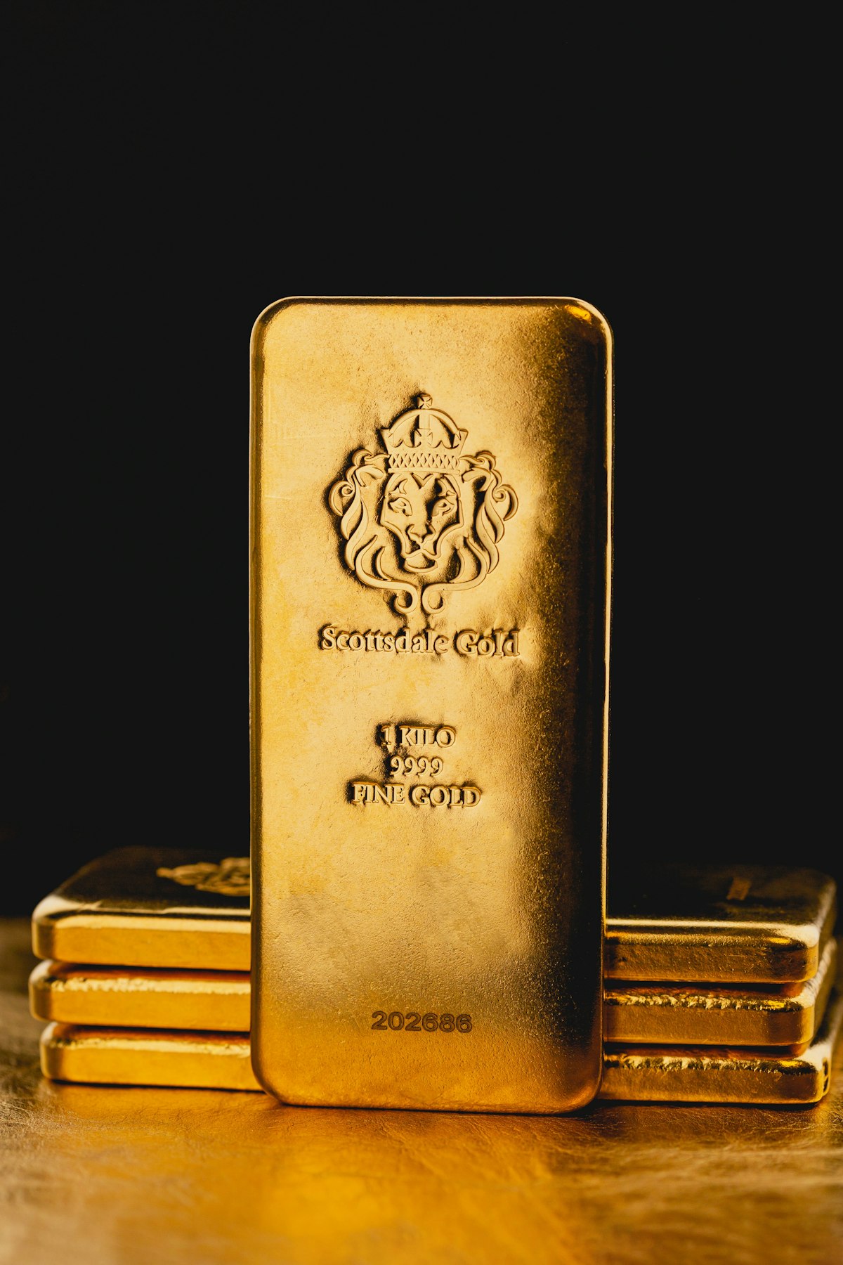Dramatic gold bars stacked on a wooden table — where to buy gold 2026