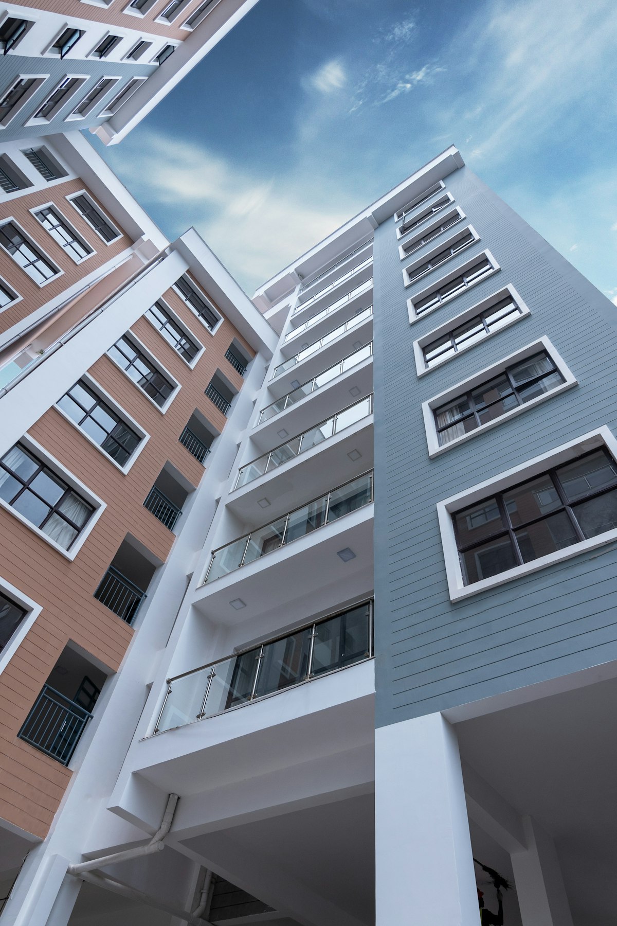 REITs vs rentals comparison — modern apartment building representing real estate investment in 2026