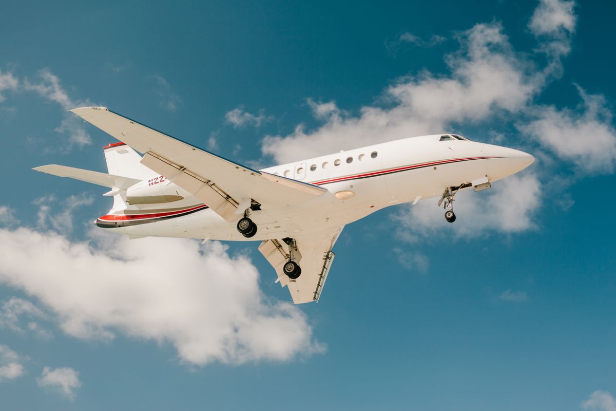 Luxury private jet in flight against blue sky — luxury travel with the best travel credit cards
