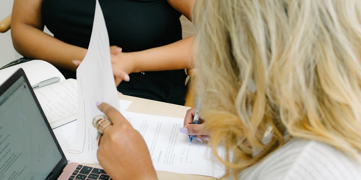Two people comparing paperwork while deciding between debt consolidation vs debt snowball