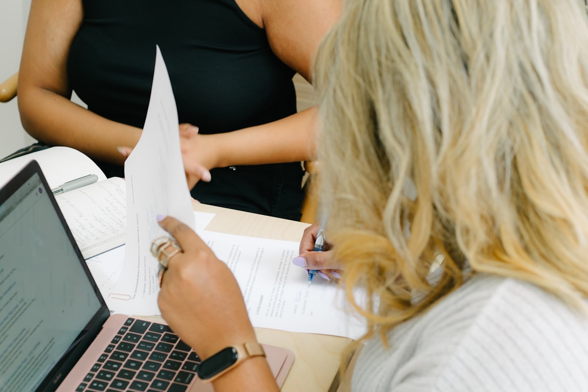 Two people comparing paperwork while deciding between debt consolidation vs debt snowball