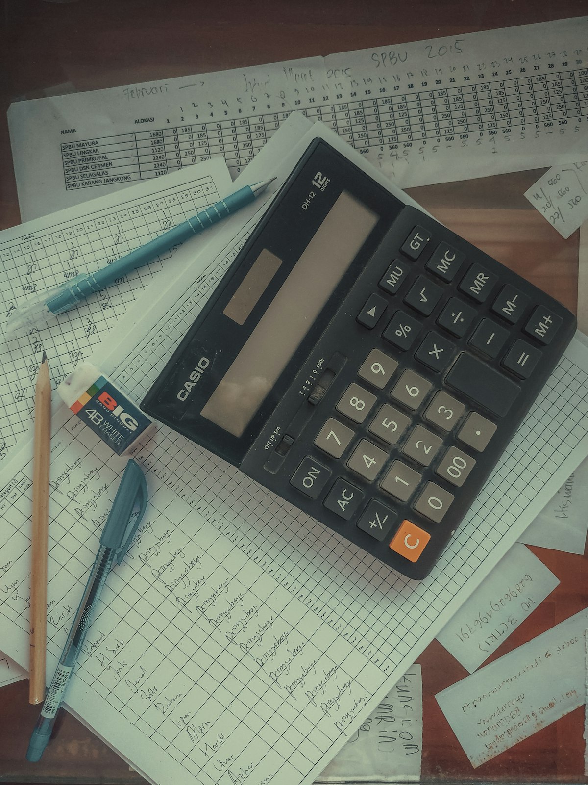 A calculator on a stack of papers representing the debt settlement vs debt payoff decision