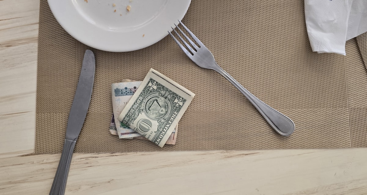 A couple reviewing bills and cash on the table while working out how to pay off debt on a low income