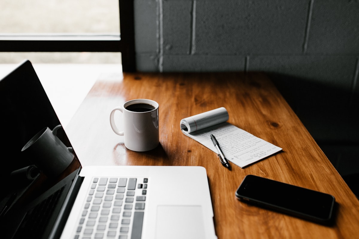 planning how to retire early with a laptop, coffee, and notes