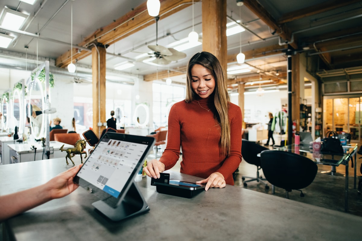 Person using a credit card at checkout while working to rebuild credit after collections