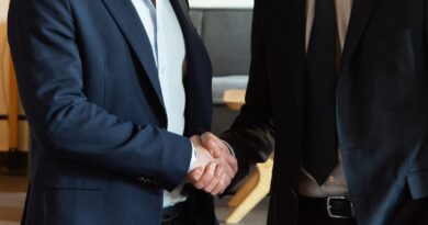 Two business partners shaking hands, representing how to become a millionaire in 2026 by acquiring a business