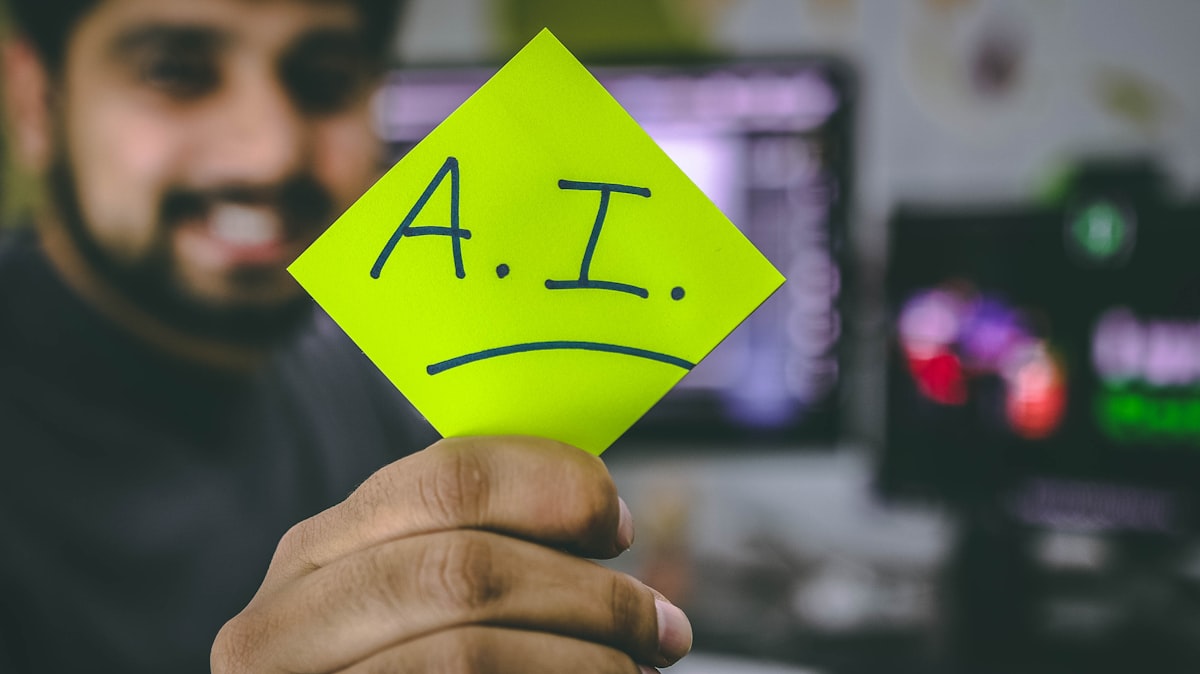 A person holding up a note that says A.I., representing the two extreme stories people tell about artificial intelligence